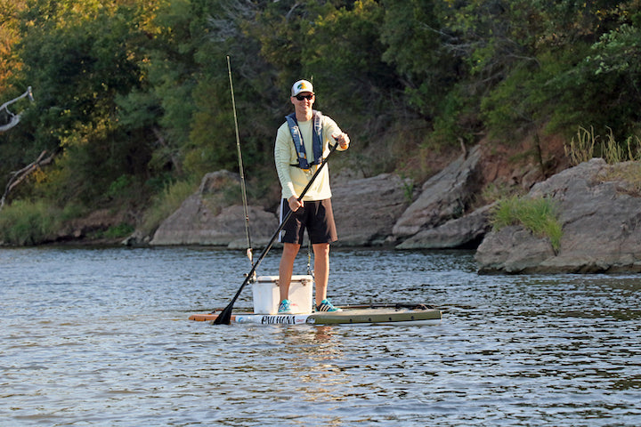 man on a SUP with an inflatable PFD