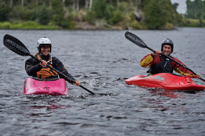 two whitewater kayakers on the water, each with an Aerial Carbon paddle