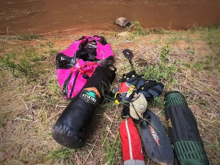 More packraft gear on the shore on the grass