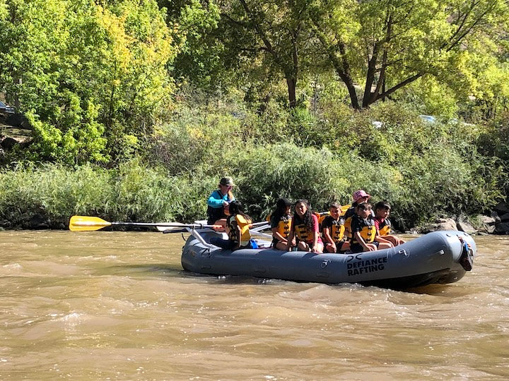 women and students rafting on a river