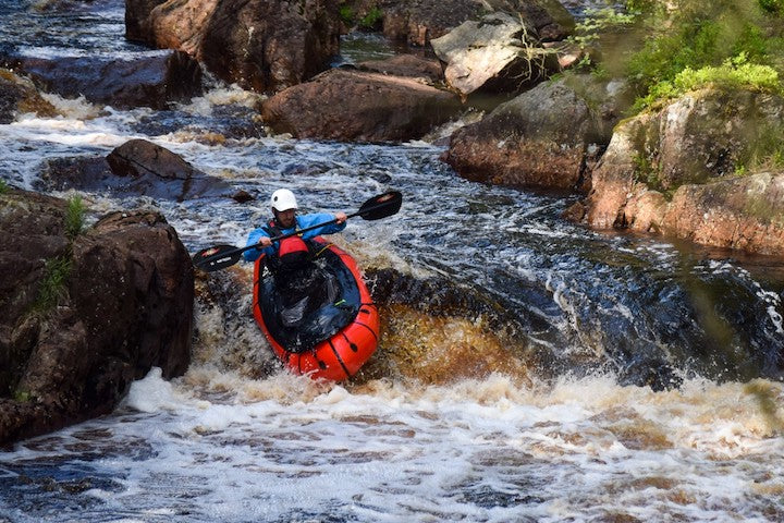 packrafter heads down a slight drop in the river