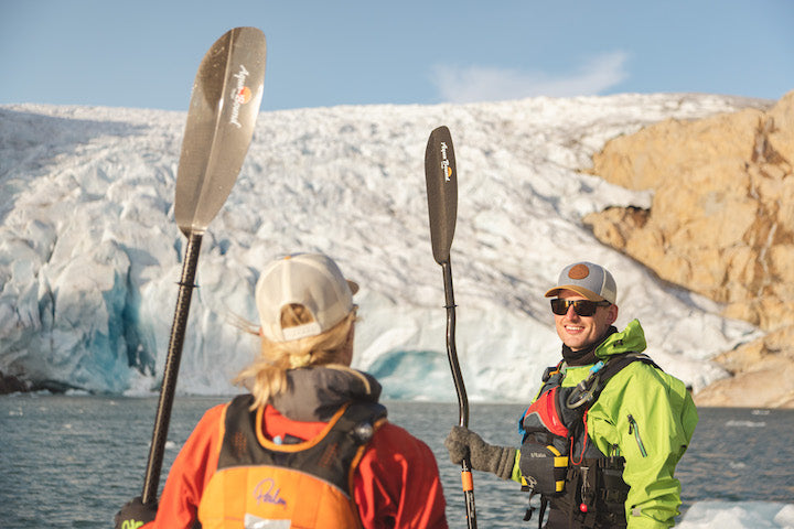 two kayakers, one with a straight shaft paddle and the other with a bent shaft paddle