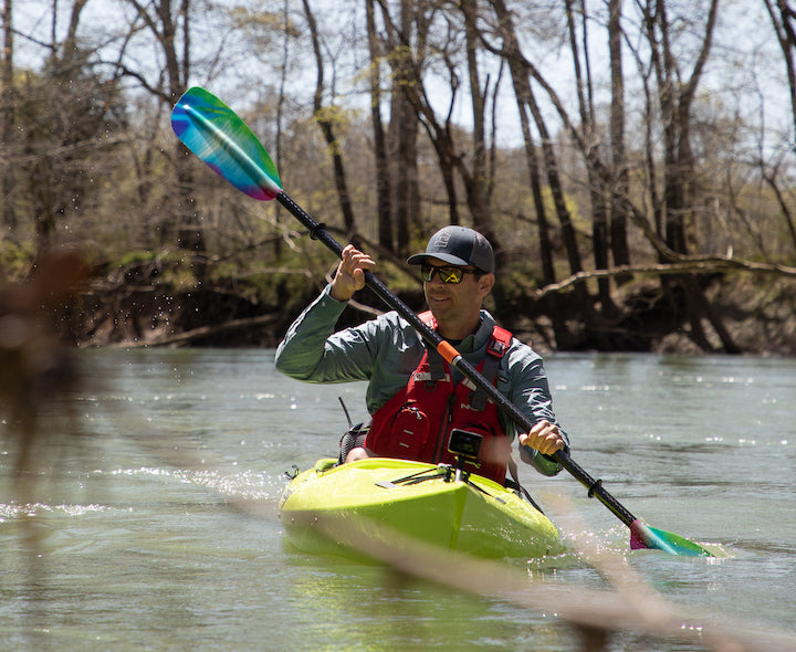 man in a round-hull kayak, on edge in the water