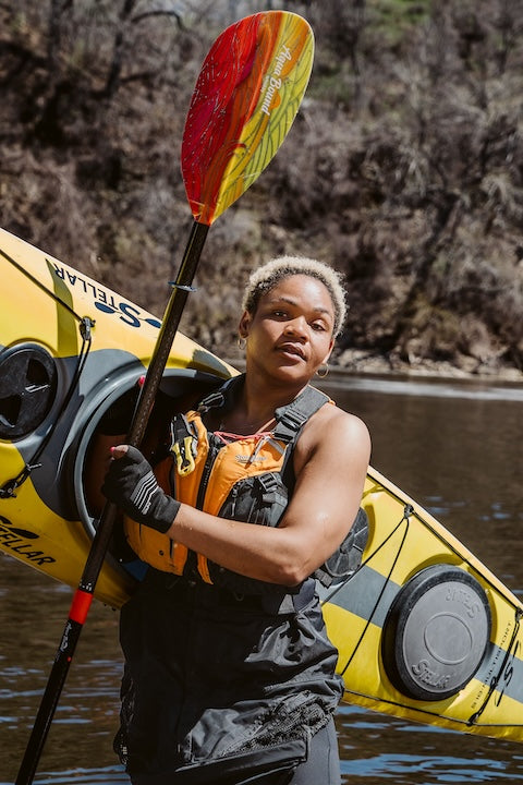 Devin Brown holds her kayak and paddle