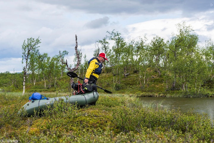 man pulling his loaded packraft to the water