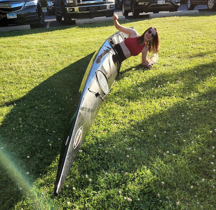 woman practices a brace in a sea kayak on the ground