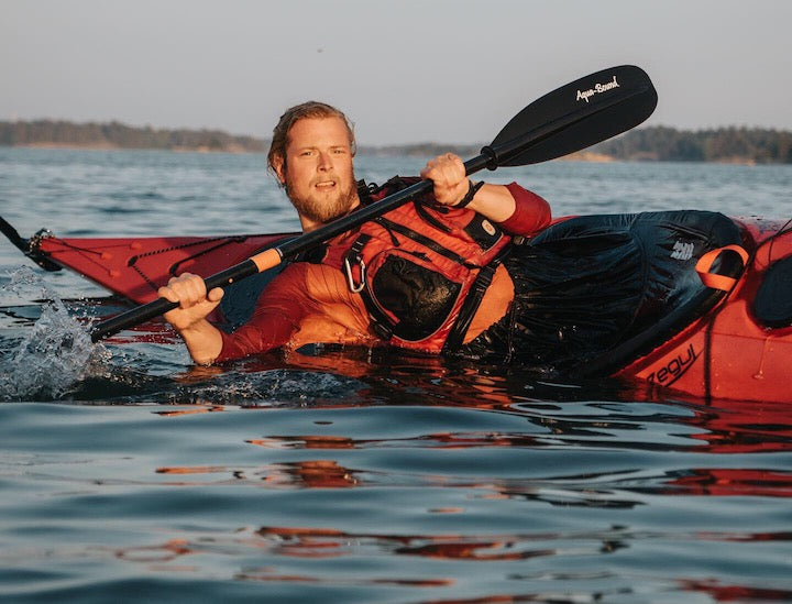 male kayaker demonstrates a brace in a sea kayak