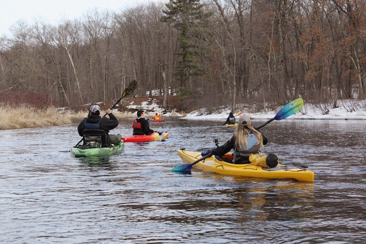 several kayakers on a river in spring