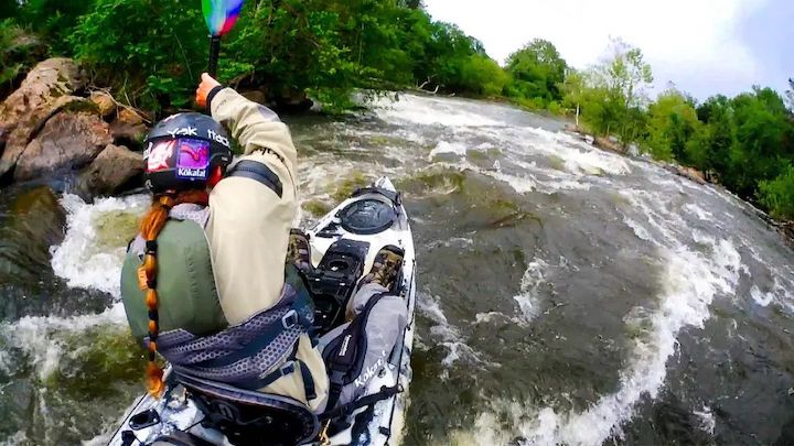 man whitewater kayaking with a fishing kayak