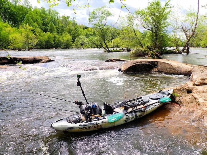 fishing kayak along a river shore