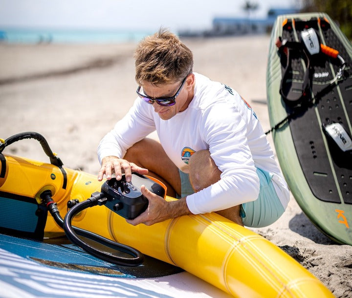 man using Puffer Pro Pump to inflate a boat