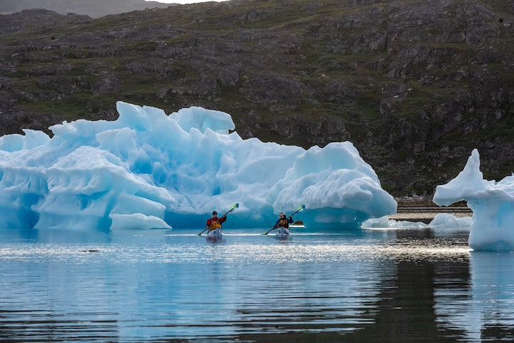 two kayakers among icebergs in Greenland