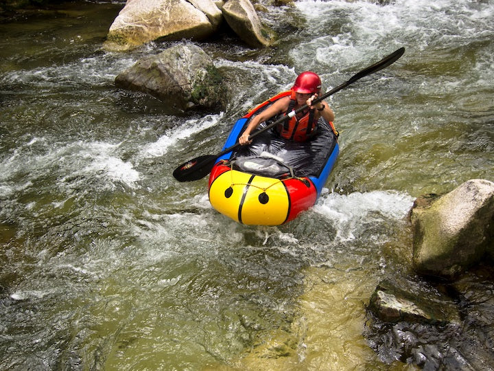 woman packrafting in rapids