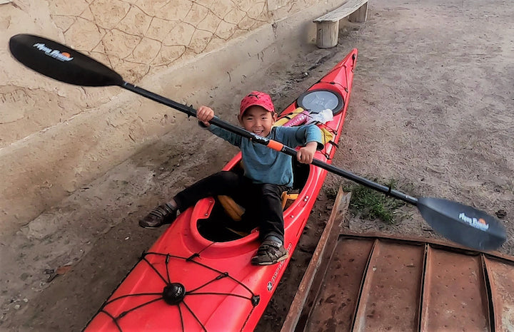 young Kyrgyz boy in Hugo's kayak on land