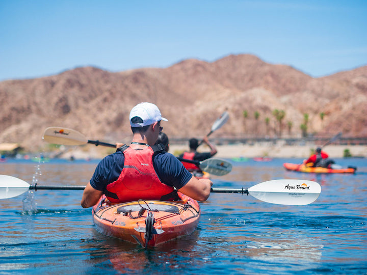 man kayaking with Aqua Bound paddle; other kayakers in background