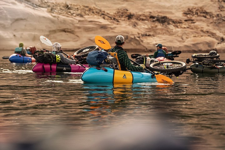 several packrafters with bikes and gear on a river