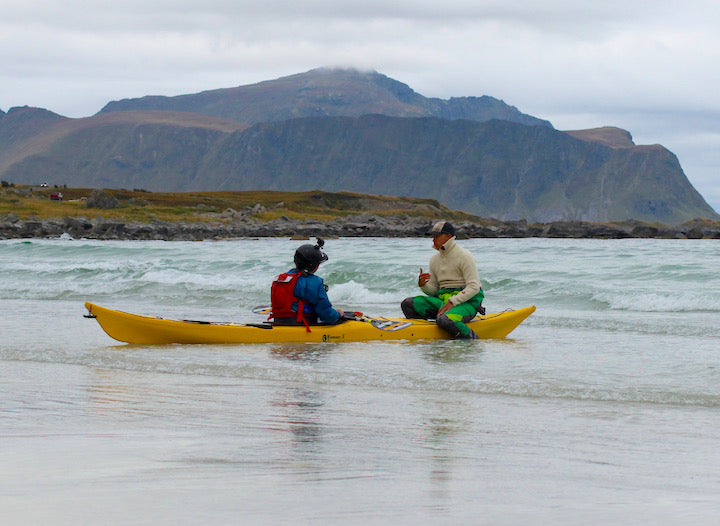 Jalle instructs a sea kayaker along the shore