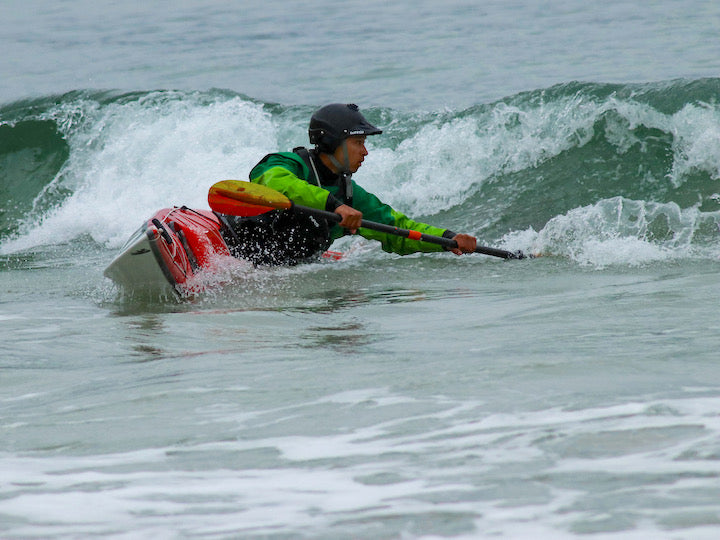 sea kayaker "surfs" a wave