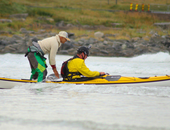 Jalle S assists a sea kayaker on the shoreline