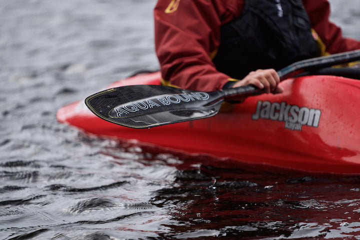 whitewater kayak holds Aqua Bound's Aerial Carbon paddle