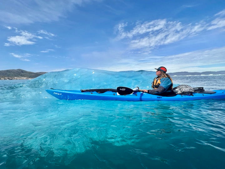 Kate Wright kayaks next to a small Greenland iceberg