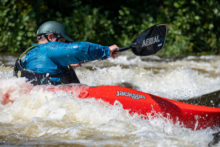 man kayaks in rough whitewater with Aqua Bound's new Aerial paddle in carbon