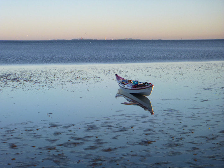sea kayak sits on the seaside at low tide