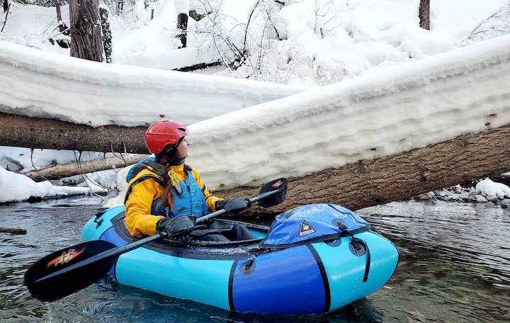 Jessica in her packraft on the river in winter