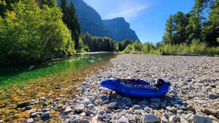blue packraft sitting on the shore next to the Methow River