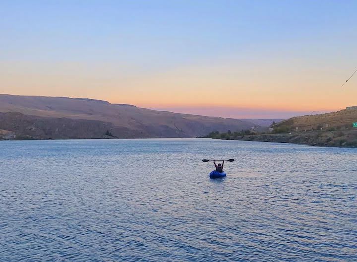 packrafter with paddle in the air at the Methow River/Columbia River confluence