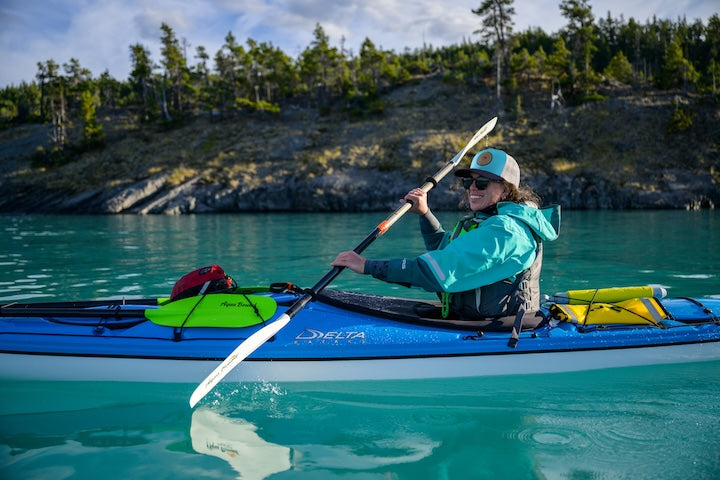 woman kayaks wearing a dry suit