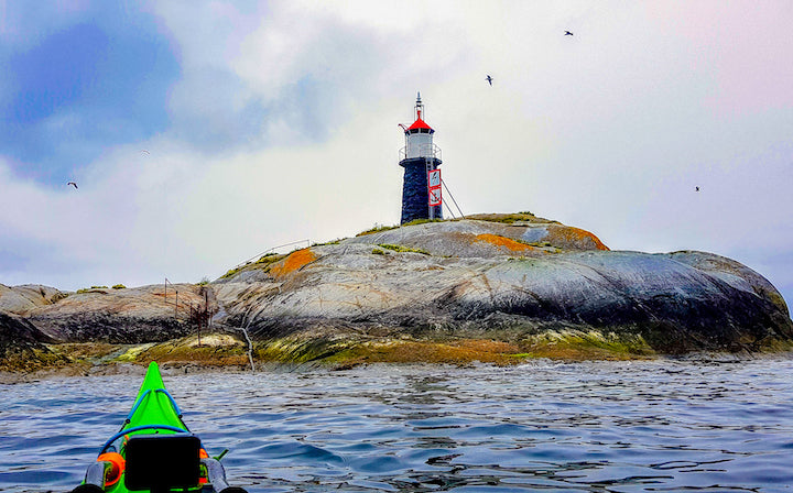 lighthouse on an island, seen from a kayak