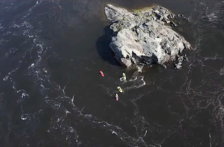 4 whitewater kayakers on the Ottawa River, next to a small rocky island