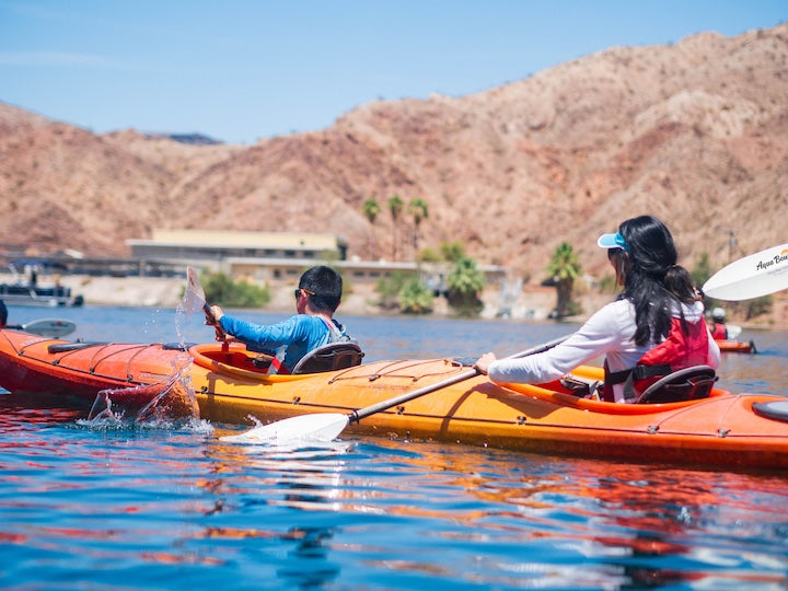 a mother and son paddle a tandem kayak together
