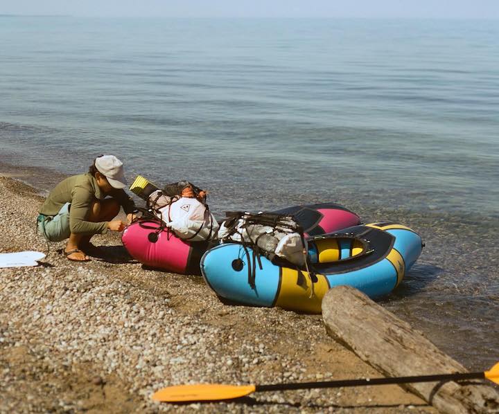 packrafter checking gear on loaded packrafts at shore