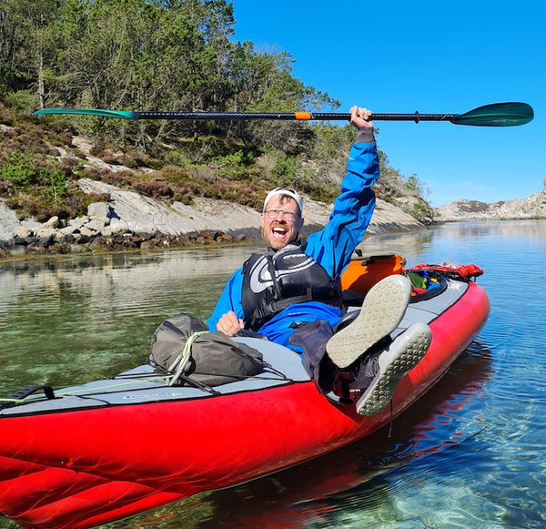 Man holding Green Tide Whiskey paddle above his head