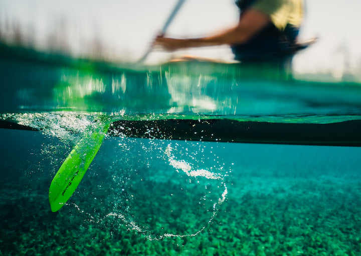 below-water view of kayak paddle blade with kayaker