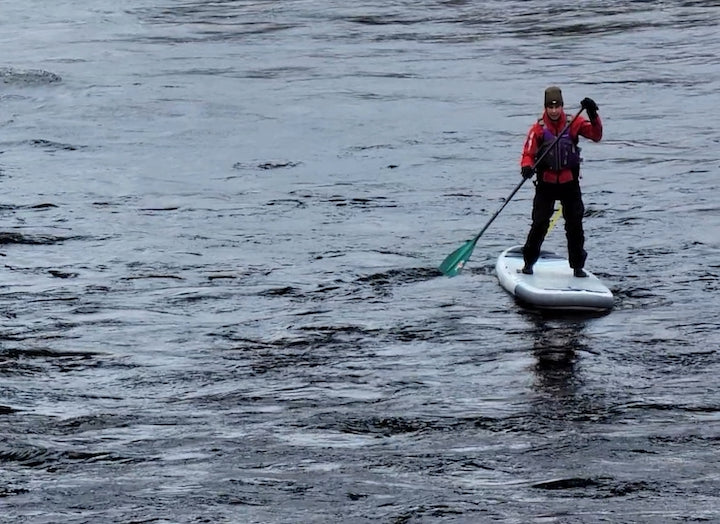 paddler on a SUP wearing a drysuit