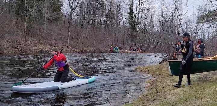 SUPer kneeling on her paddleboard to start her race