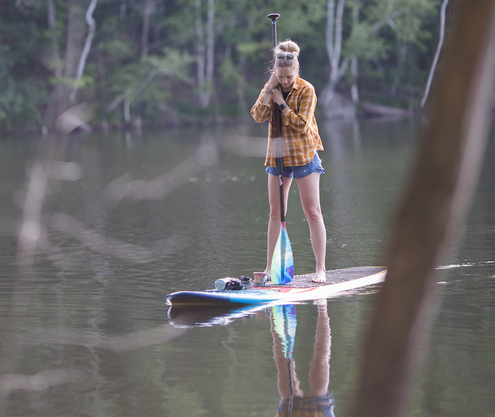 woman relaxing on a paddle board on a calm lake