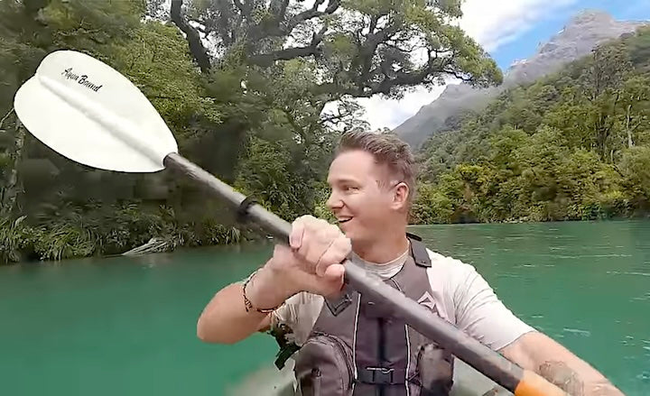 Scott Williams paddles on a green NZ lake with his Aqua Bound paddle
