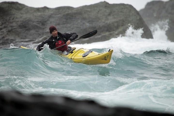 man sea kayaking in waves