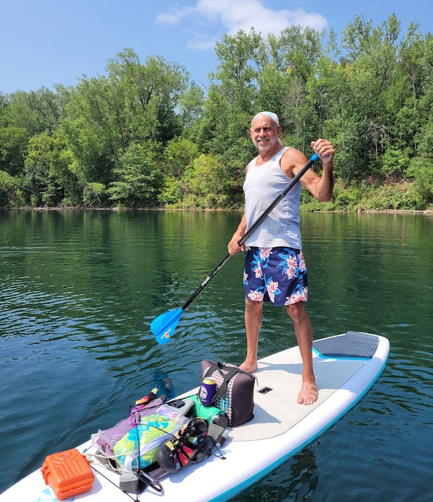 TCK owner, John Schulte, on a paddleboard on the water