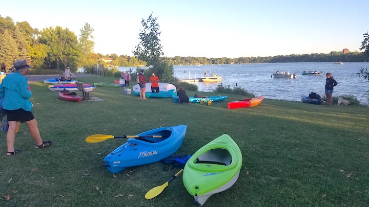 kayaks and paddles on the shore waiting for people to take them on the lake