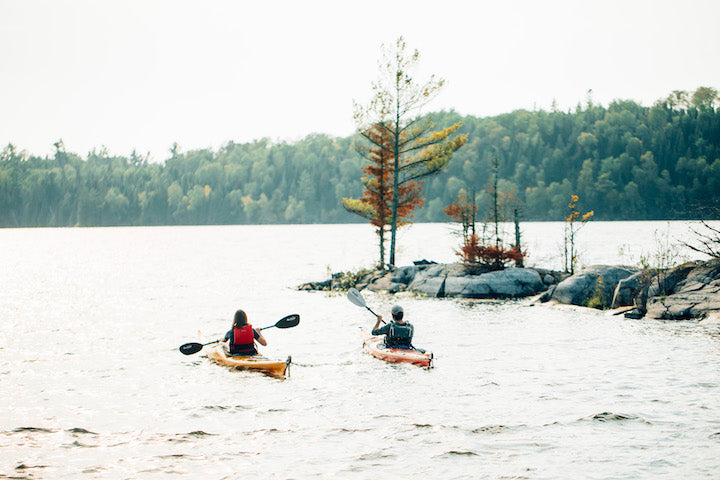 two kayakers on a wilderness lake