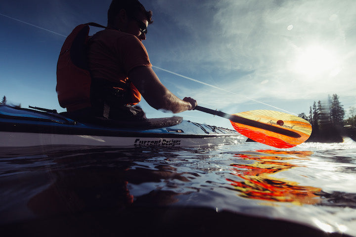 kayaker with whiskey fiberglass paddle