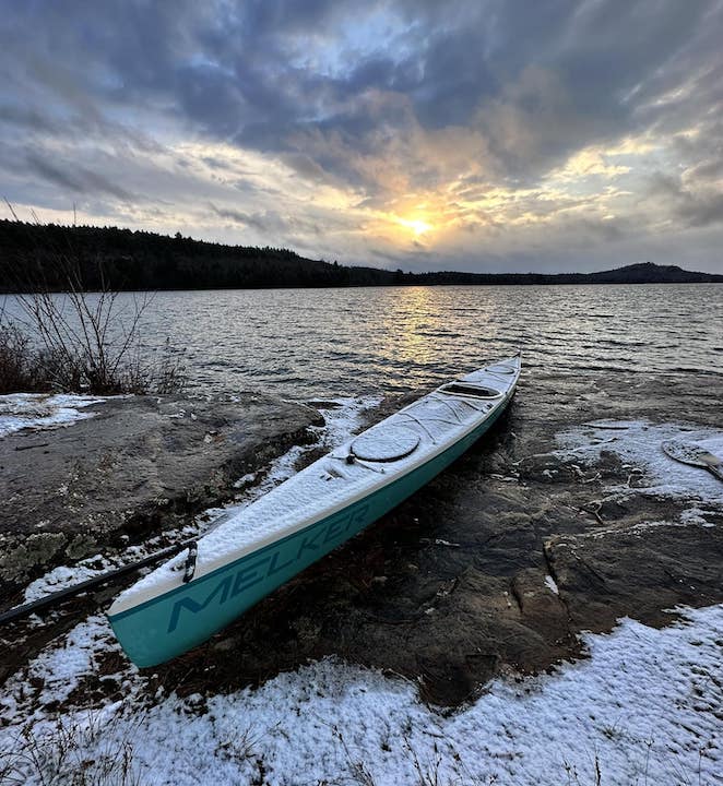 sea kayak on a lakeshore in the snow