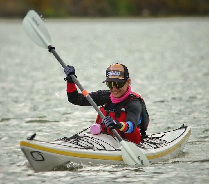 woman in a white kayak paddling