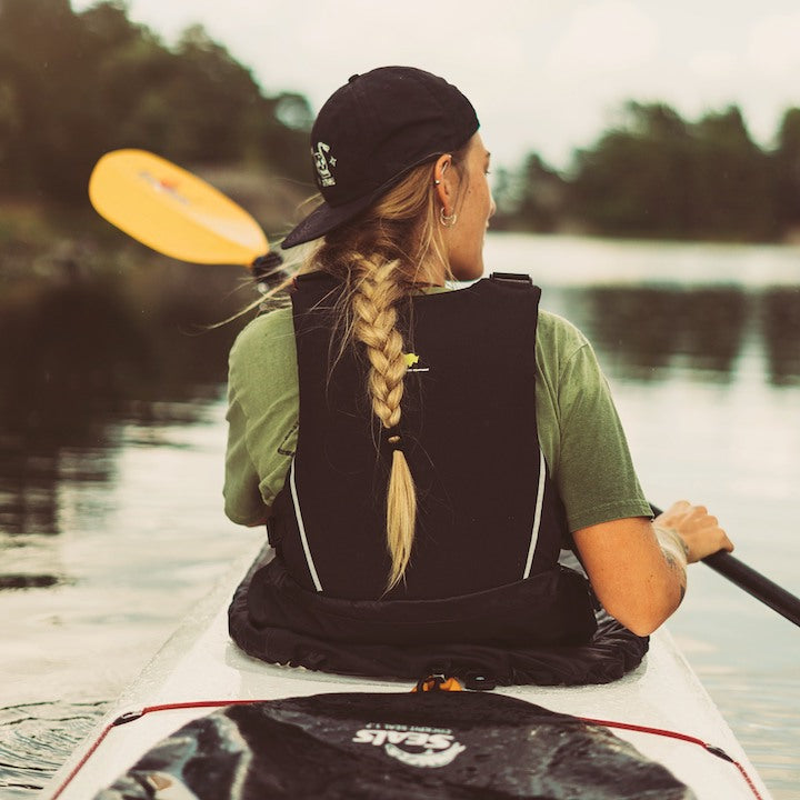 woman in the front of a tandem kayak, paddling