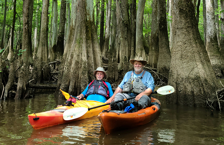 Two kayakers relaxing near bald cypress trees in Congaree National Park